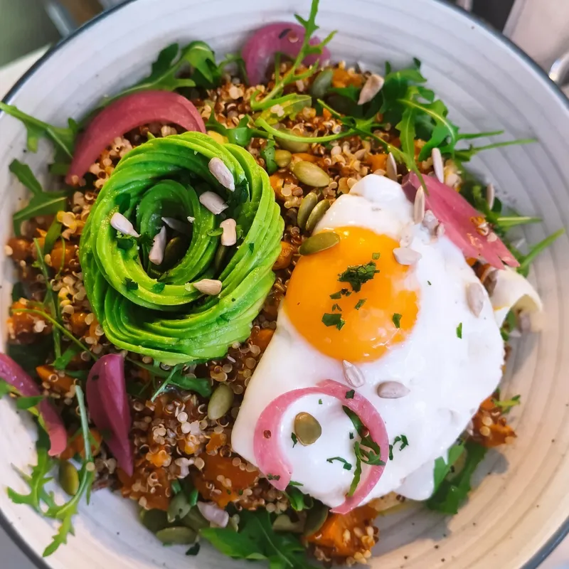 Harvest nourish bowl with quinoa, avocado and a fried egg