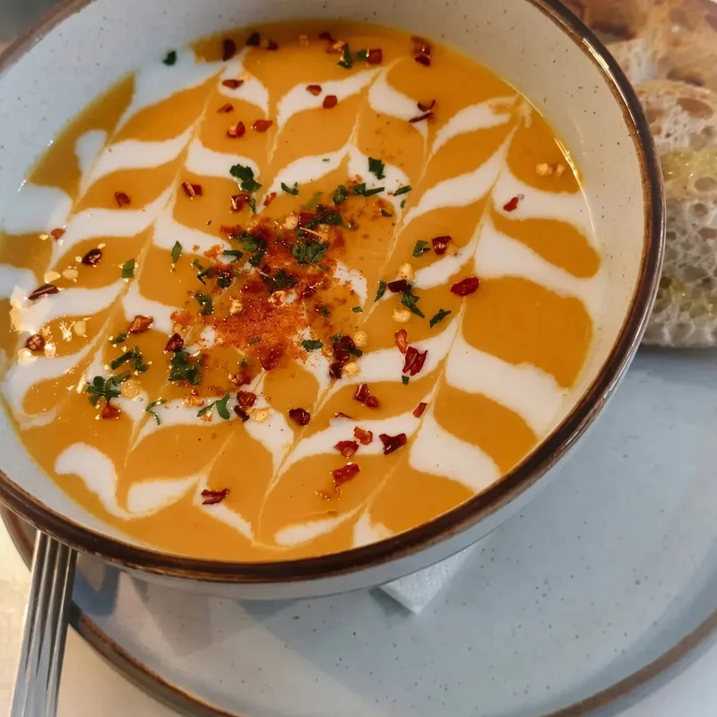 Homemade soup with a cream swirl and crusty bread